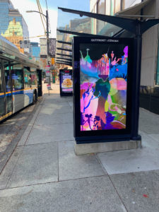 Transit shelter with my artwork - digital screen of drawing of hand and pik and landscape.